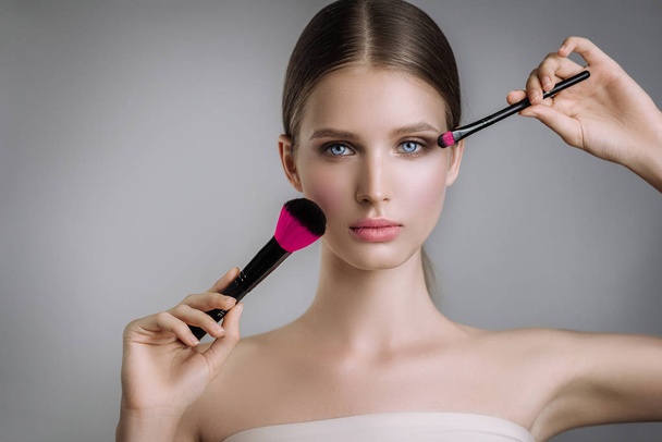 beauty portrait beautiful girl posing with makeup brushes - 写真・画像