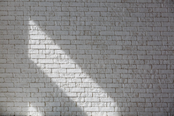 Солнце отбрасывает на белую бетонную стену тень
 - Фото, изображение