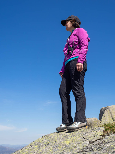 Una señora madura con vistas a la campiña escocesa desde un punto de vista alto en las colinas durante una caminata
 - Foto, imagen