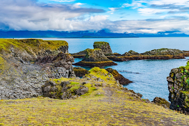 Natural landscape of beautiful mossy cliff and basalt rocks formation at Arnarstapi Village in Iceland - Φωτογραφία, εικόνα