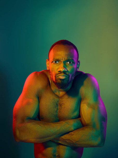 Close up portrait of a young naked african man looking at camera indoors - Photo, Image