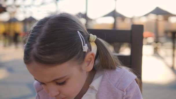 Menina engraçada cinco anos comendo um sanduíche no parque em um café
 - Filmagem, Vídeo