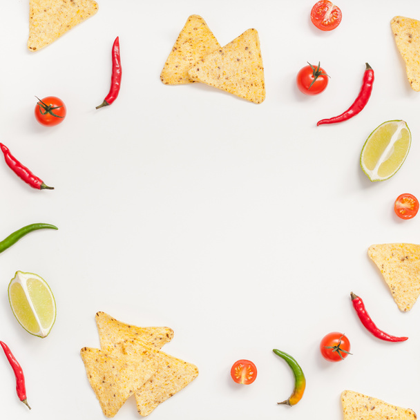 kreative Draufsicht flach lag von frischen mexikanischen Lebensmitteln Zutaten mit Tortilla Nachos Chips Knoblauch Pfeffer Limetten Tomaten auf weißem Tischhintergrund mit Kopierraum. Essenszubereitung Kochen quadratischer Rahmen - Foto, Bild