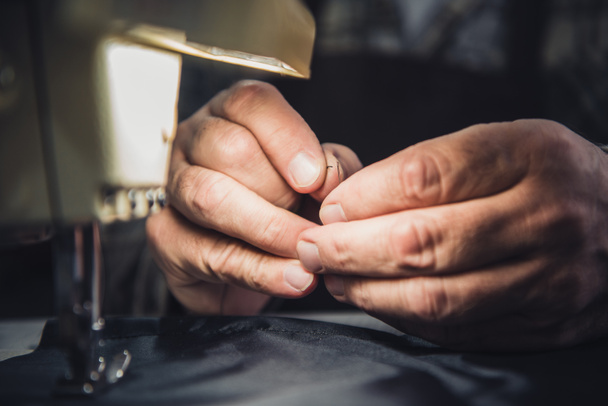 cropped image of male handbag craftsman sewing at studio - Foto, immagini
