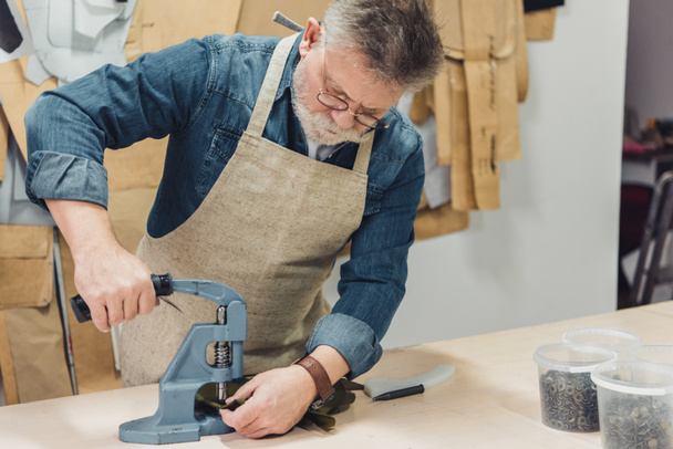 koncentrované starší mužské kabelka řemeslník pracující s nástrojem ve studiu - Fotografie, Obrázek