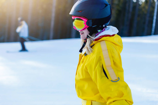 Mujer en traje de invierno amarillo montando esquís en montañas nevadas
  - Foto, Imagen