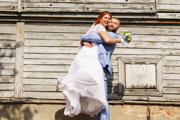 ちょうど愛するヒップスター夫婦の結婚式でドレスし、合わせて古い木造家屋の前でポーズします。幸せな花嫁と花婿を実行して、ダンスを歩きます。ロマンチックな結婚している若い家族。秋の結婚式 - 写真・画像