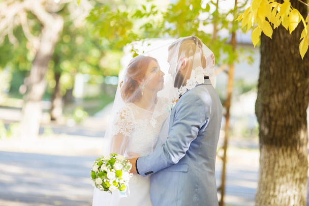 Jen milující bokovky manželé v svatební šaty a obleky v parku. Šťastná nevěsta a ženich, chůzi, běh a tanec. Romantický oženil s mladou rodinu. Podzimní svatba - Fotografie, Obrázek