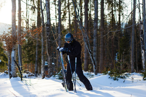Uomo felice in tuta da sci nera appoggiato sulla neve bianca
 - Foto, immagini