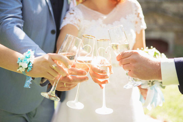 人々は白ワインと手のメガネを保持します。結婚式だ。シャンパンで乾杯する友達 - 写真・画像