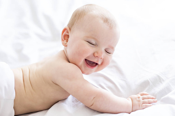 A Baby girl in white bedding at home look nice - Fotoğraf, Görsel