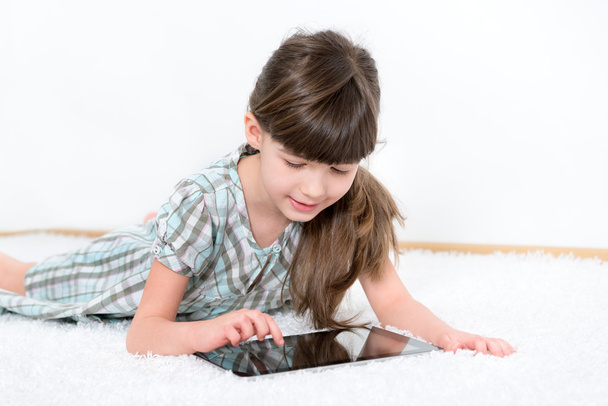 Little girl playing with a tablet - Foto, imagen