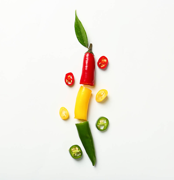 Flat lay composition with slices of colorful chili peppers on white background - Fotografie, Obrázek