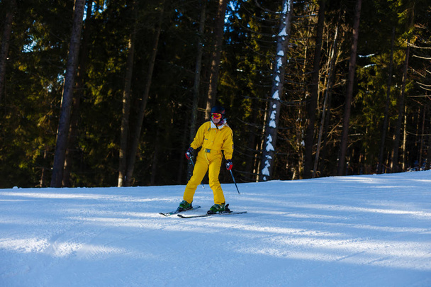 Nő a lovaglás a havas hegyek Ski téli sárga színû munkaruhában  - Fotó, kép