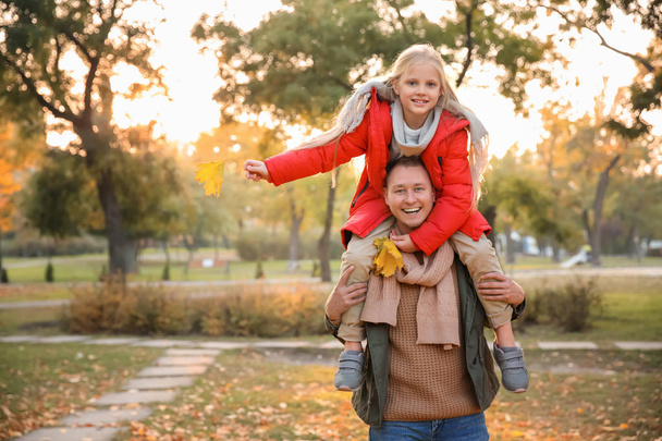 Щасливий батько і його маленька дочка в осінньому парку
 - Фото, зображення