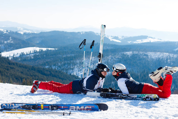Пара в лыжных костюмах, позирующих в зимнем лесу
 - Фото, изображение