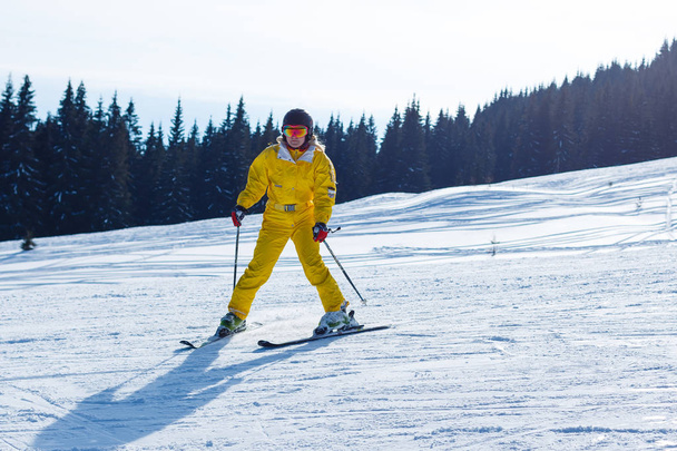 Female skier standing on slope of mountain hill - Photo, Image