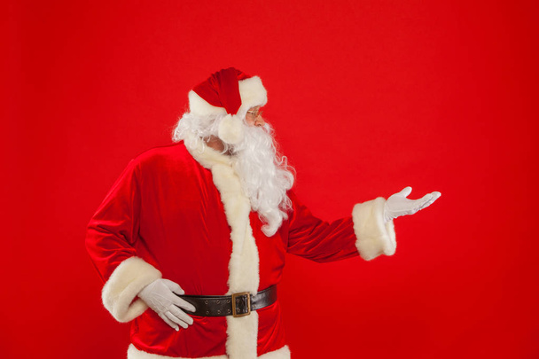 Santa Claus pointing in blank a place, red background - Foto, immagini