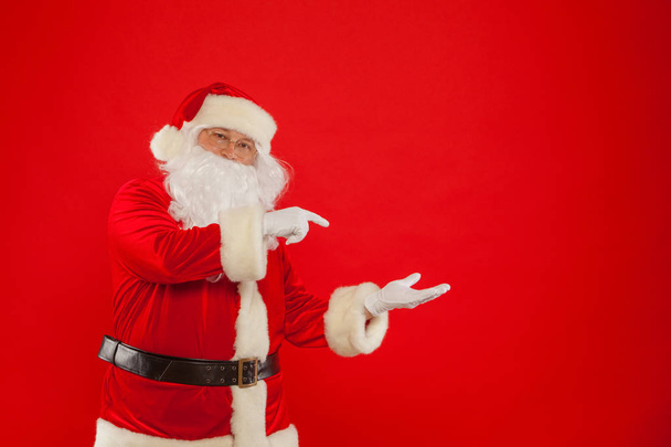 Santa Claus pointing in blank a place, red background - Fotografie, Obrázek