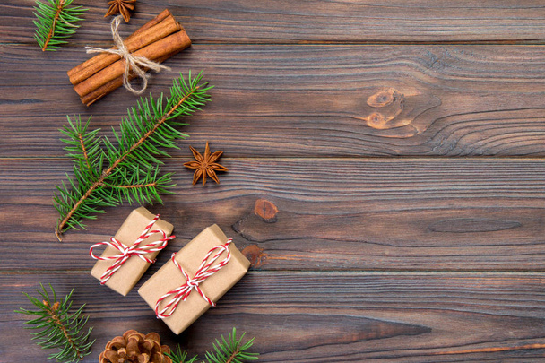 Різдвяний фон з ялинкою та подарунковою коробкою на дерев'яному столі. Вид зверху з пробілом для копіювання вашого дизайну
. - Фото, зображення