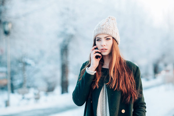 Young  woman smiling with smart phone and winter landscape . - Fotografie, Obrázek