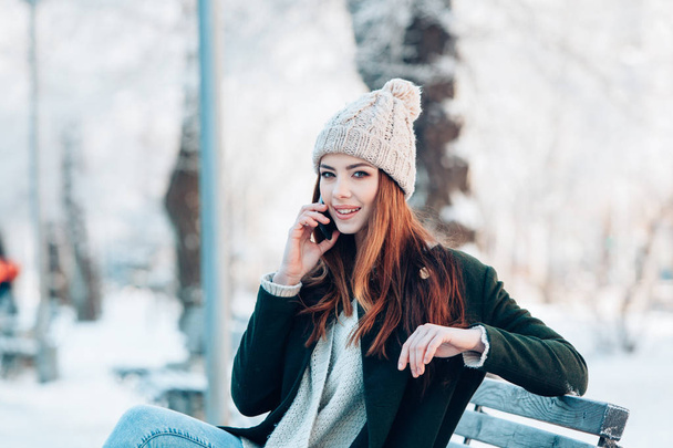 Young  woman smiling with smart phone and winter landscape . - Φωτογραφία, εικόνα