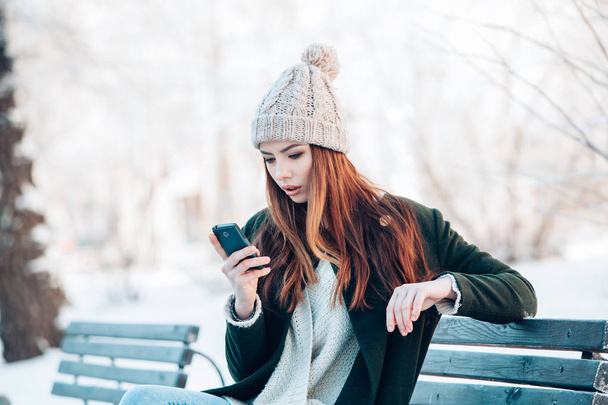 Young  woman smiling with smart phone and winter landscape . - Fotoğraf, Görsel