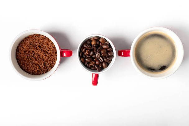 Cups with grind coffee, beans and beverage on white background - Foto, afbeelding