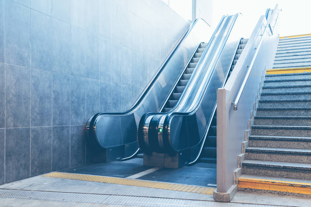 Prise plein cadre d'un escalier en pierre à côté d'un escalier roulant moderne
 - Photo, image