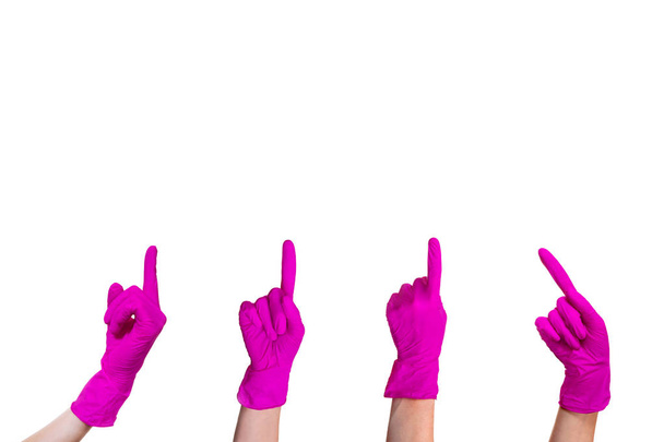 Žena s rukama ve fialové lékařské rukavice ukazující cestu ukazováček. Čtyři zbraně izolovaných na bílém pozadí. - Fotografie, Obrázek
