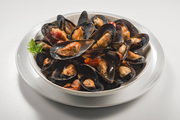 Bowl with soup of mussels and parsley isolate on white background - Photo, Image