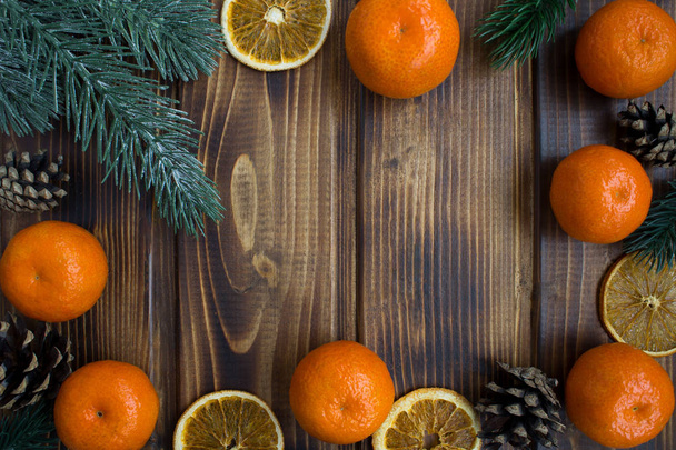 Christmas composition with tangerines on the brown wooden background.Top view.Copy space. - Zdjęcie, obraz