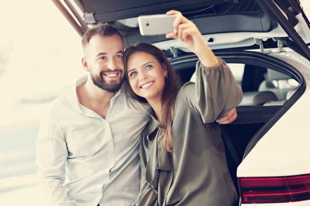 Adult couple choosing new car in showroom - Valokuva, kuva
