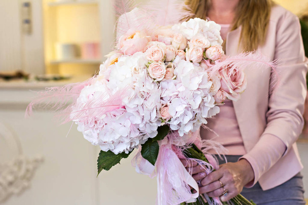 Beautiful bouquet with delicate flowers - roses and hydrangeas. Pink and white bouquet. Bridal bouquet in female hands. - Photo, image