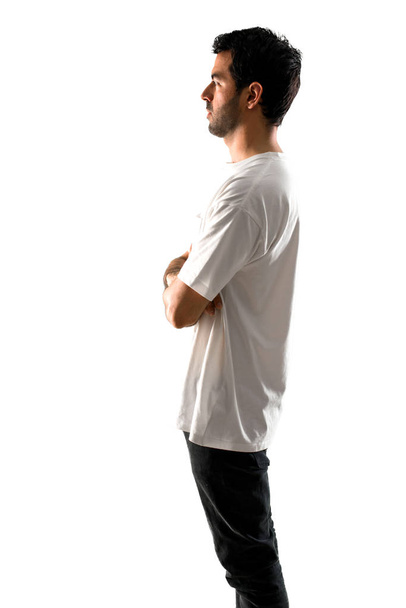 Hombre joven con camisa blanca en posición lateral sobre fondo blanco aislado
 - Foto, Imagen