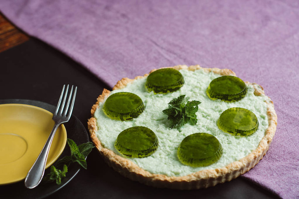 Freshly baked homemade  pie with jelly and mint on a dark background - 写真・画像
