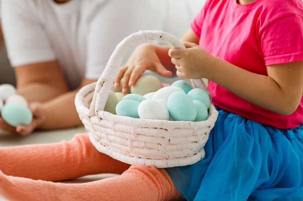 child holding a basket with colorful eggs - Fotoğraf, Görsel