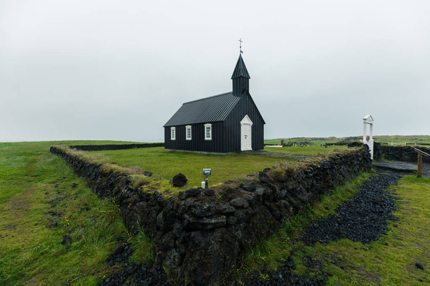 green grasslands during the rainy day near the Bakirkja Black Church in Iceland - Fotó, kép
