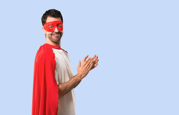 Superhrdina muž s maskou a červená mys tleskají po prezentaci na konferenci o izolované modré pozadí - Fotografie, Obrázek