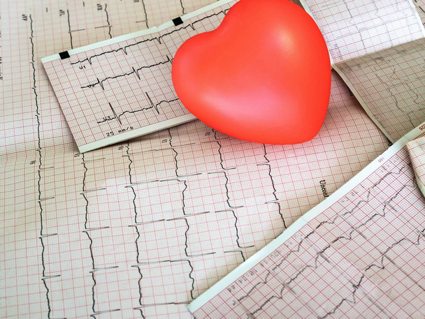 Kardiogramm mit kleinem roten Herz auf dem Tischhintergrund. Ansicht von oben, Kopierraum - Foto, Bild