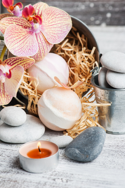 Spa still life with bath bombs, pebbles and red orange orchid on wooden background - Fotografie, Obrázek