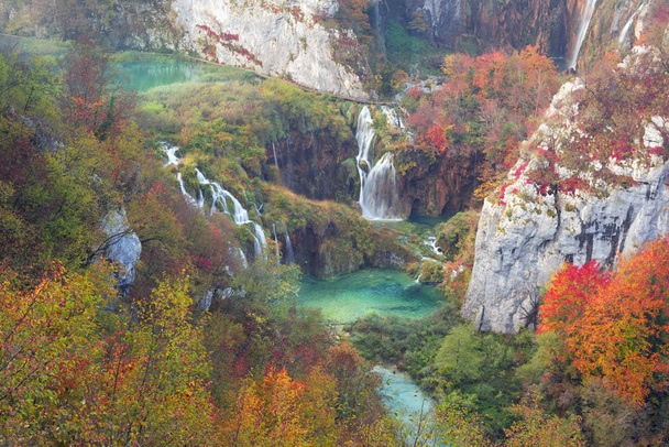 Plitvice şelaleler Hırvatistan Avrupa'da çok güzel ünlü ünlü yerlerden biri. Su jetleri, gündoğumu, sonbahar ormanlarının arka plan üzerinde çok güzel - Fotoğraf, Görsel