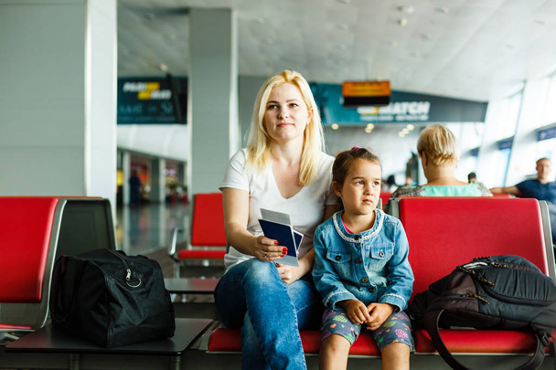 Młoda matka i córka czekają na odlot w poczekalni na lotnisku - Zdjęcie, obraz