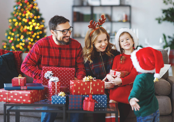 ευτυχισμένη οικογένεια γονείς και παιδιά Ανοίξτε δώρα στο Χριστουγεννιάτικο Καλημέρα - Φωτογραφία, εικόνα