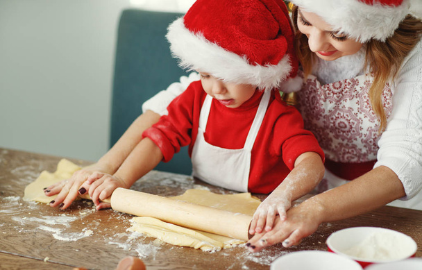 feliz divertida madre y el niño hornear galleta de Navidad
 - Foto, Imagen