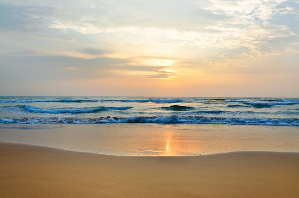 海の波と低太陽の前で瞑想 - 写真・画像