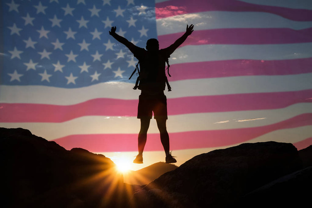 Celebrando el Día de la Independencia. Hombre saltando sobre acantilados, bandera de EE.UU. en el fondo
 - Foto, imagen