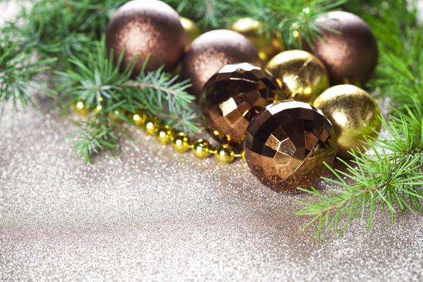 Christmas decorations and evergreen fir tree branch closeup on gold glitter background. - Foto, Bild