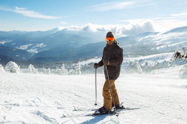 Nice man skiing in the mountains. Good skiing in the snowy mountains,  Winter is coming, first snowfall. Ski resort season is open. Ski equipment, trail. - Valokuva, kuva