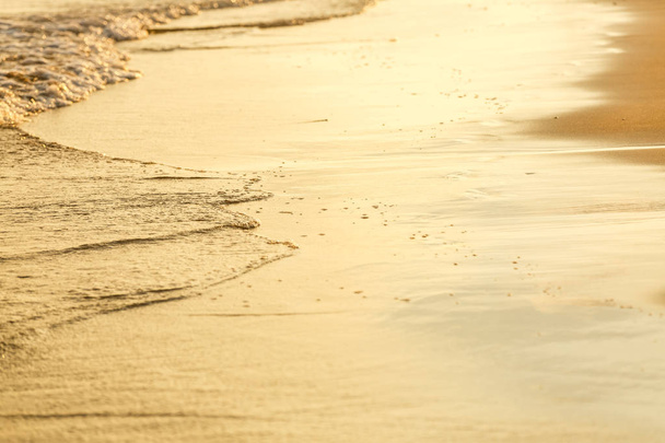 Vista cercana de las olas del océano en la playa de arena al atardecer
 - Foto, Imagen